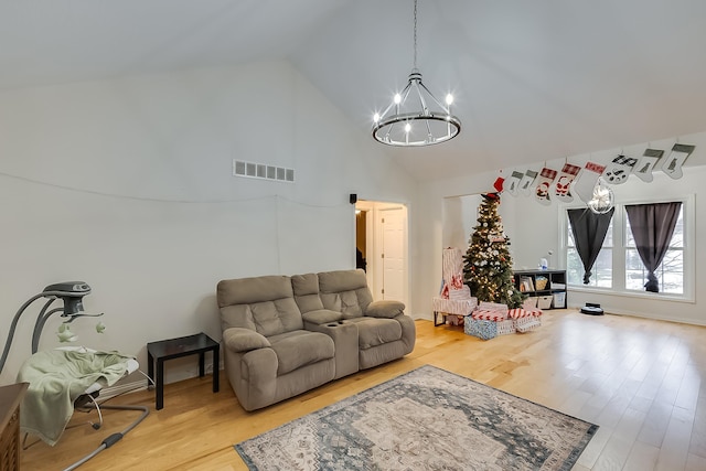 living room with a chandelier, high vaulted ceiling, and wood-type flooring