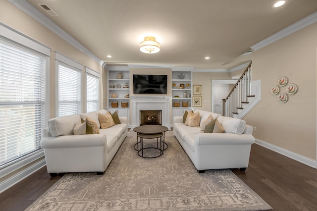 living room with built in shelves, hardwood / wood-style floors, ornamental molding, and a healthy amount of sunlight