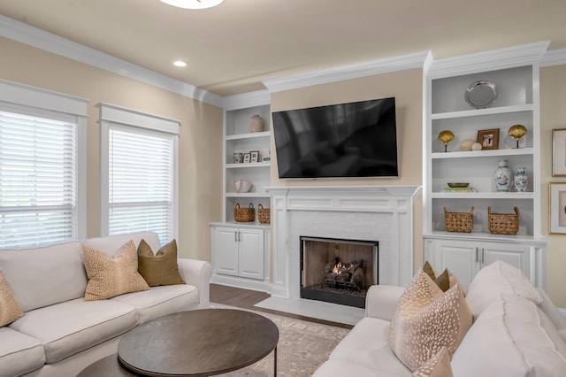 living room with built in shelves, crown molding, and light hardwood / wood-style flooring