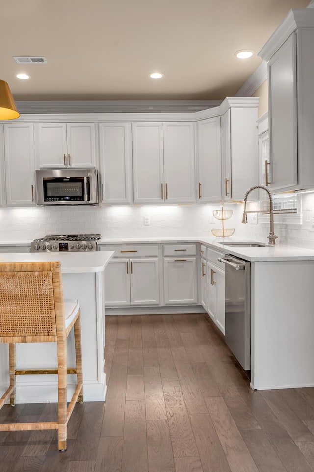 kitchen featuring decorative backsplash, stainless steel appliances, sink, light hardwood / wood-style flooring, and white cabinetry