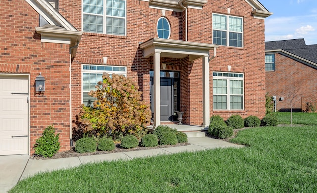 property entrance with a yard and a garage