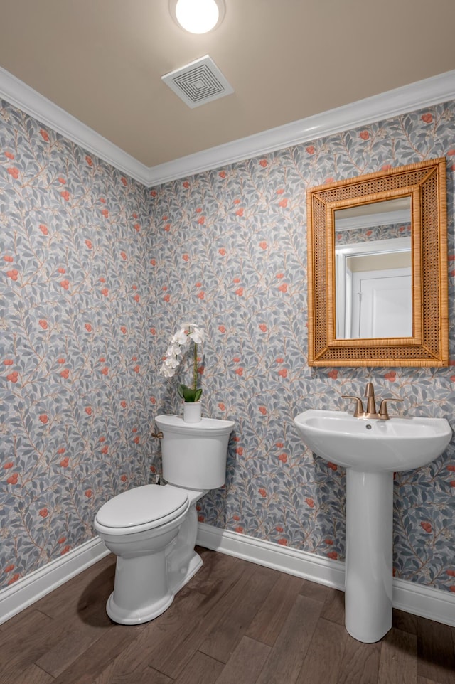 bathroom featuring toilet, wood-type flooring, and ornamental molding