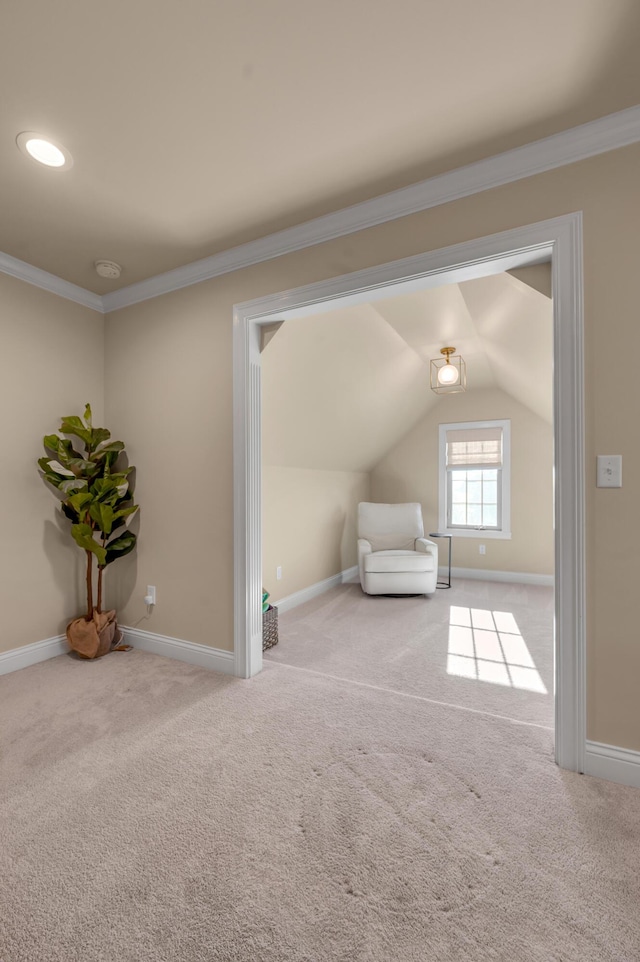 unfurnished room featuring light colored carpet, lofted ceiling, and crown molding