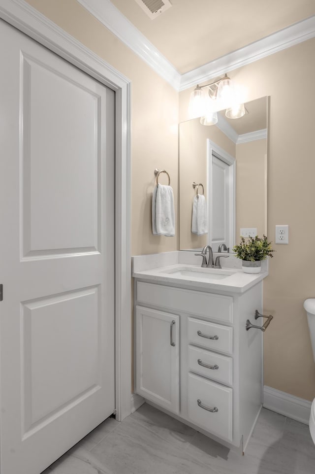 bathroom with vanity, toilet, and crown molding