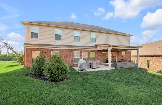 rear view of house with an outdoor living space, a patio, ceiling fan, and a lawn