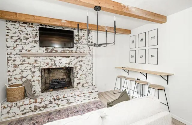 living room with beamed ceiling, light hardwood / wood-style floors, and a fireplace