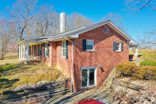 view of side of property with brick siding and a yard