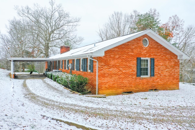 view of snow covered exterior with a carport