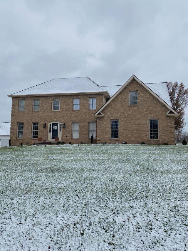 snow covered property featuring a lawn