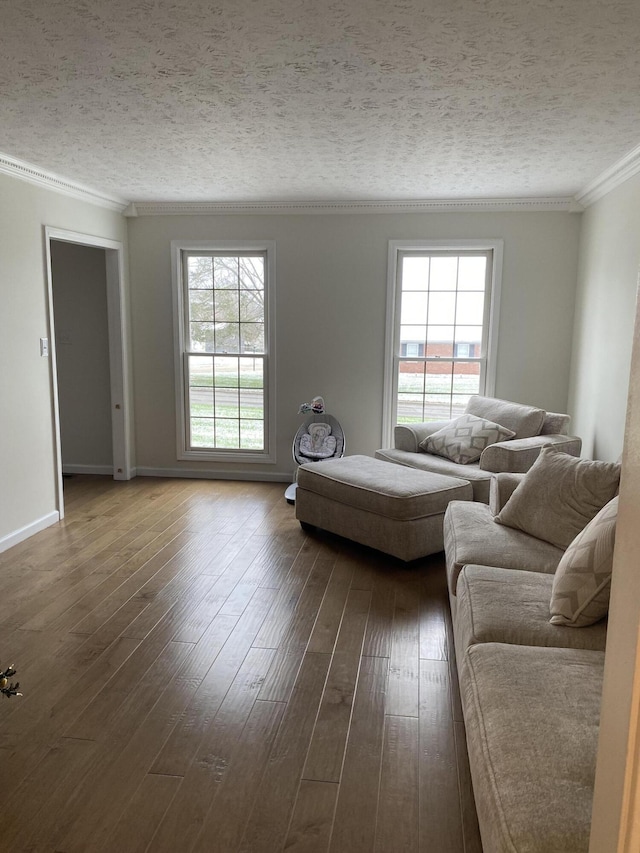 unfurnished living room with a healthy amount of sunlight, dark hardwood / wood-style flooring, ornamental molding, and a textured ceiling