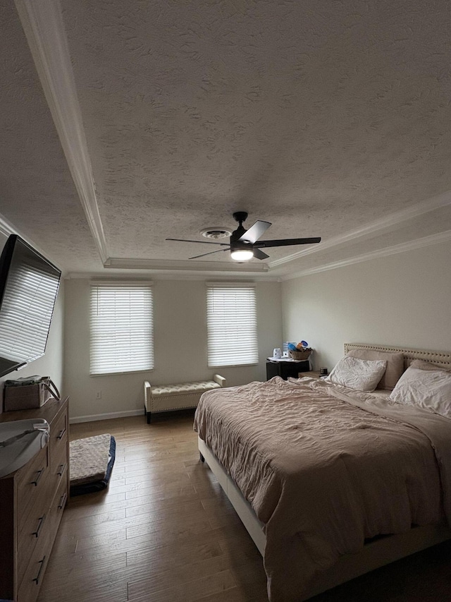 bedroom with hardwood / wood-style floors, a textured ceiling, multiple windows, and ceiling fan