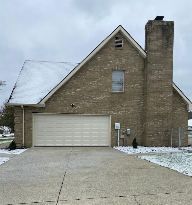 snow covered property featuring a garage