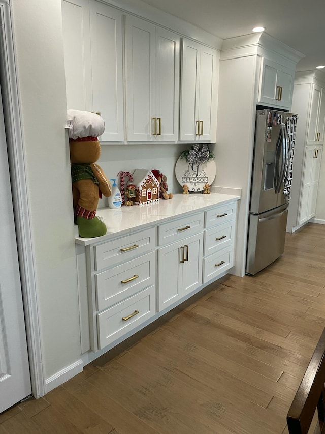 kitchen featuring white cabinetry, stainless steel refrigerator with ice dispenser, and light hardwood / wood-style flooring