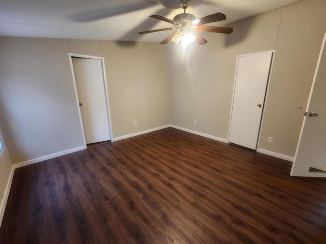 unfurnished bedroom with baseboards, a ceiling fan, and dark wood-style flooring