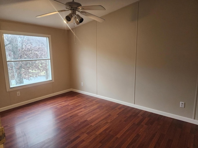 empty room with baseboards, ceiling fan, and dark wood-style flooring