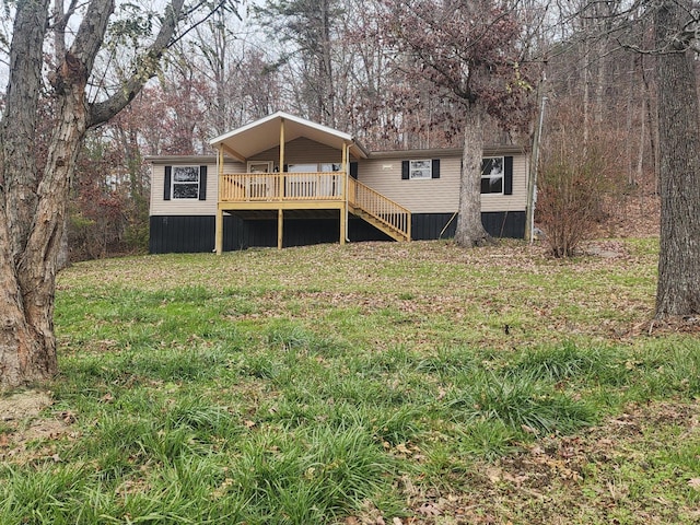 rear view of property featuring a yard and a deck