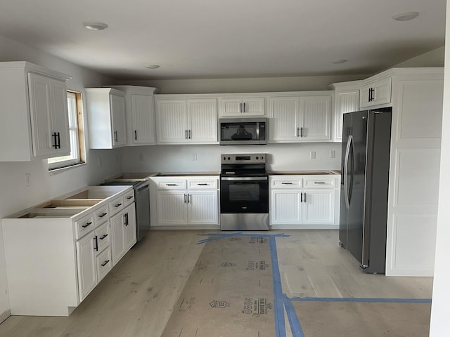 kitchen featuring white cabinetry, appliances with stainless steel finishes, and light hardwood / wood-style flooring