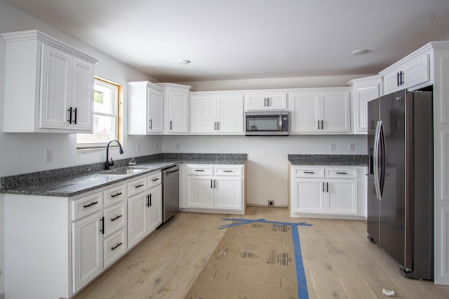 kitchen featuring white cabinetry, appliances with stainless steel finishes, and light hardwood / wood-style flooring