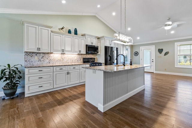 kitchen with an island with sink, stainless steel appliances, dark hardwood / wood-style floors, and ornamental molding