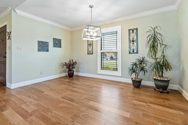 dining room with light wood-type flooring, crown molding, and an inviting chandelier