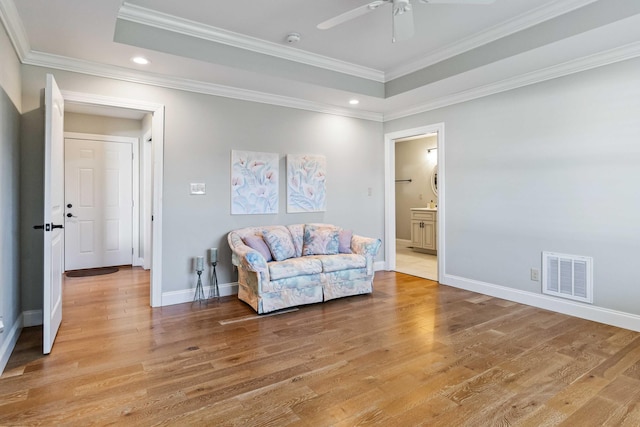 sitting room featuring ceiling fan, ornamental molding, and light hardwood / wood-style flooring