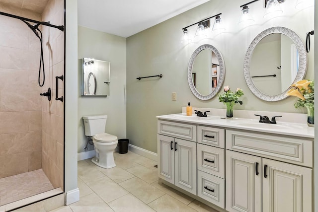 bathroom featuring a tile shower, tile patterned flooring, vanity, and toilet