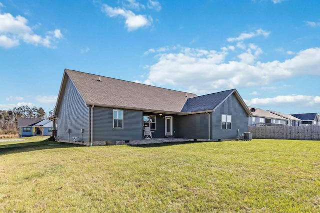 rear view of property featuring cooling unit and a lawn