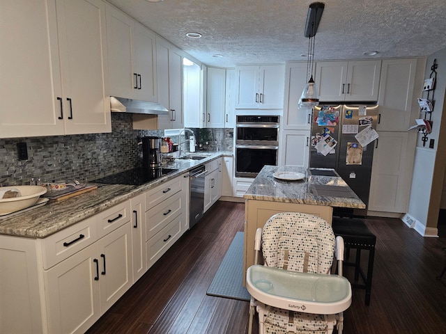 kitchen with a kitchen island, appliances with stainless steel finishes, pendant lighting, sink, and white cabinets