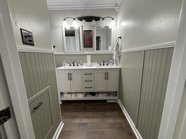 bathroom with crown molding, vanity, wooden walls, and wood-type flooring