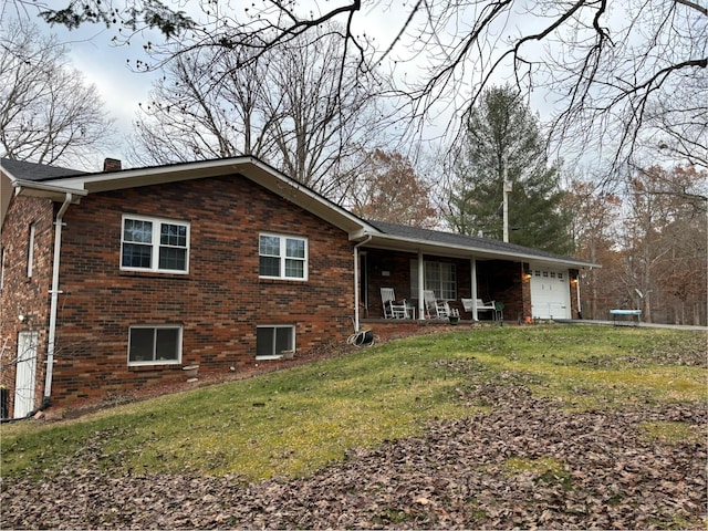 view of front of home with a garage, covered porch, and a front lawn