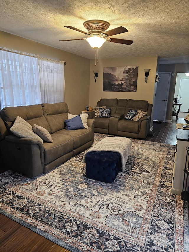 living room featuring a textured ceiling, dark hardwood / wood-style floors, and ceiling fan