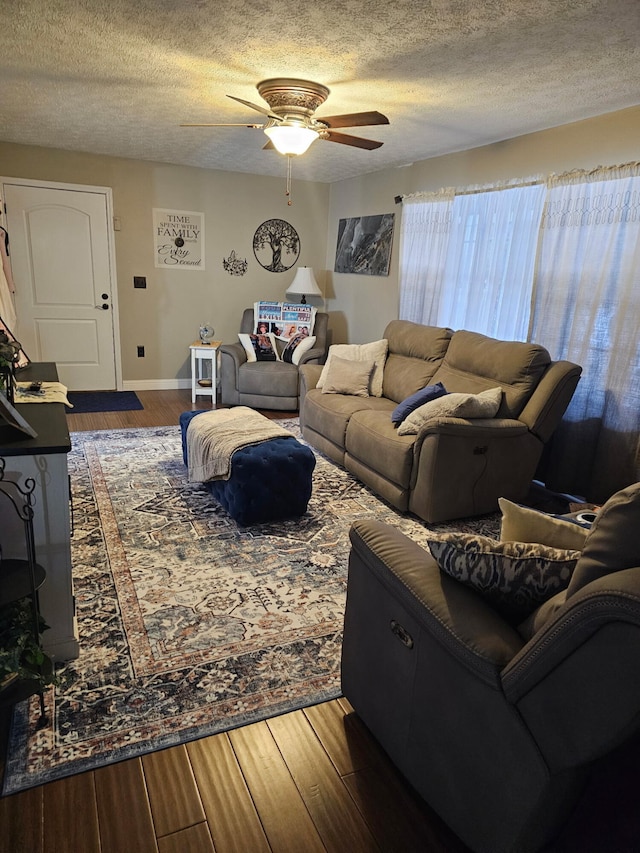 living room featuring a textured ceiling, wood-type flooring, and ceiling fan