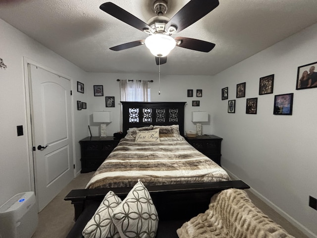 carpeted bedroom with ceiling fan and a textured ceiling