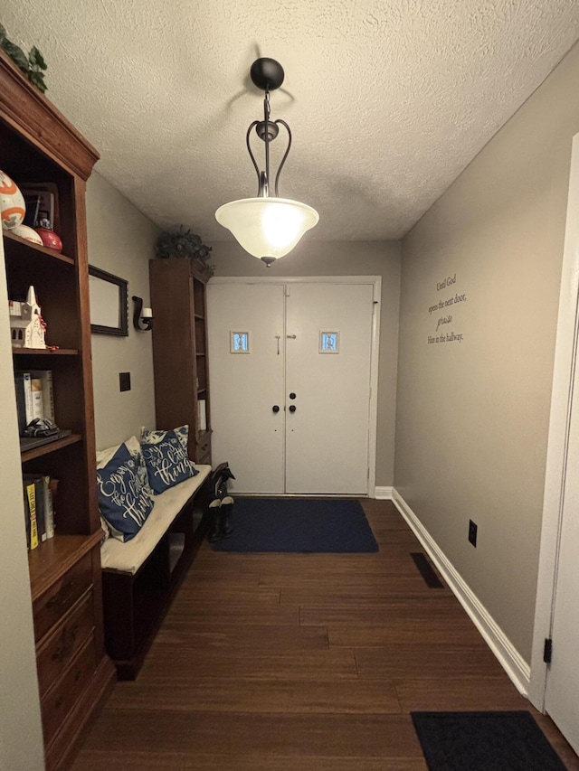 doorway to outside featuring dark hardwood / wood-style flooring and a textured ceiling