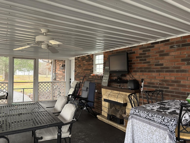 sunroom / solarium with ceiling fan and a fireplace