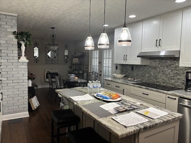 kitchen with white cabinetry, black electric stovetop, and a kitchen island