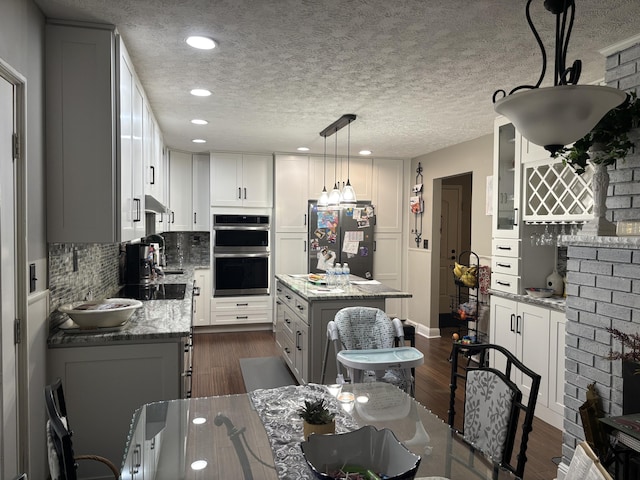 interior space with sink, dark wood-type flooring, and a textured ceiling