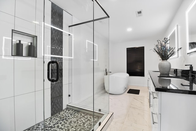 bathroom with vanity and separate shower and tub