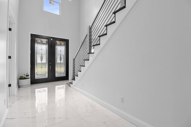 entryway featuring a towering ceiling and french doors