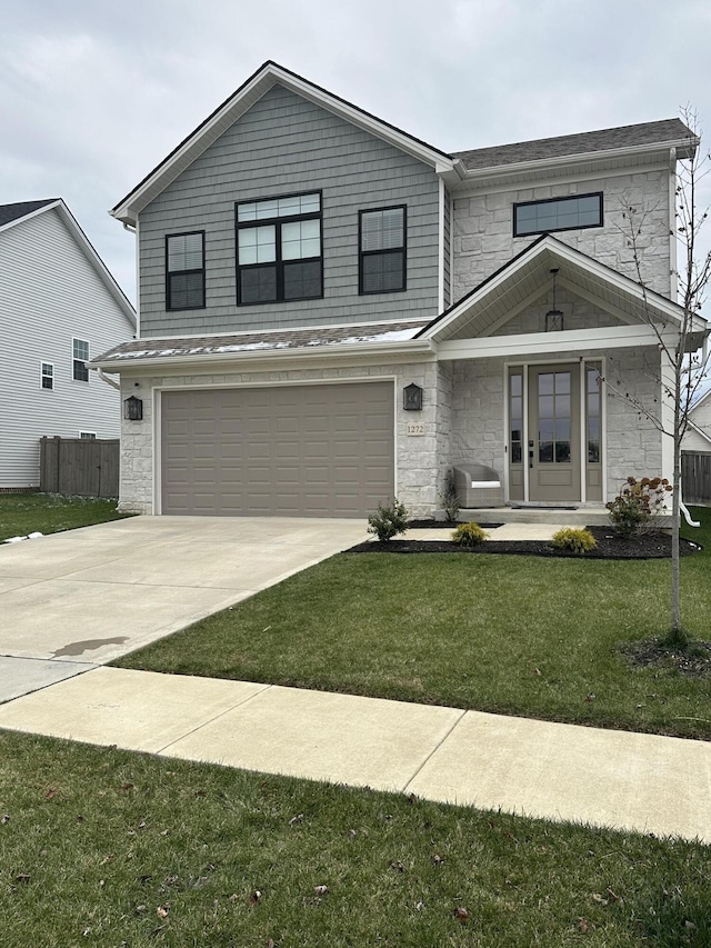 view of front of property with a front yard and a garage