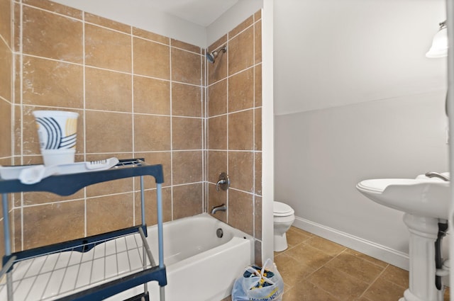 full bathroom with tile patterned floors, tiled shower / bath combo, toilet, and sink