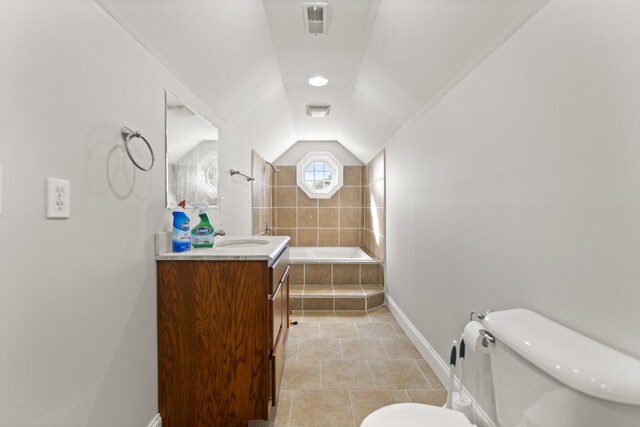 bathroom with tile patterned flooring, vanity, toilet, and vaulted ceiling