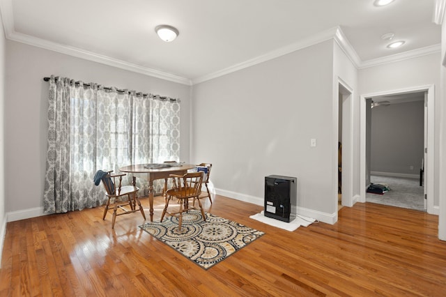 dining area featuring wood-type flooring and ornamental molding