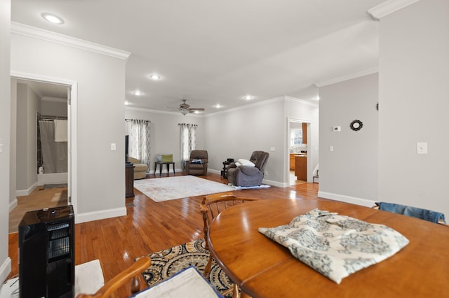 dining area featuring wood-type flooring, ceiling fan, and crown molding