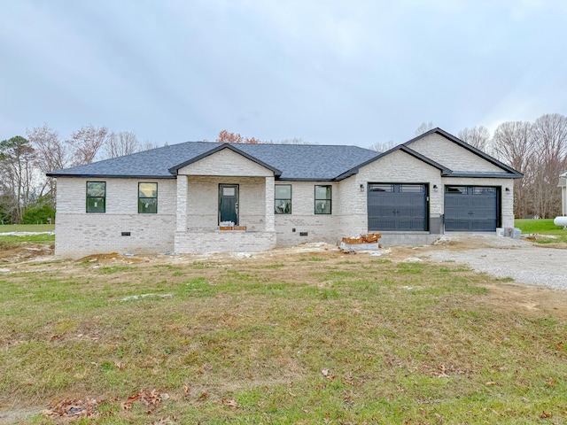 view of front of property featuring crawl space, an attached garage, gravel driveway, and a front yard