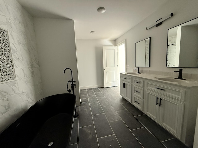 full bathroom featuring double vanity, a freestanding bath, baseboards, and a sink