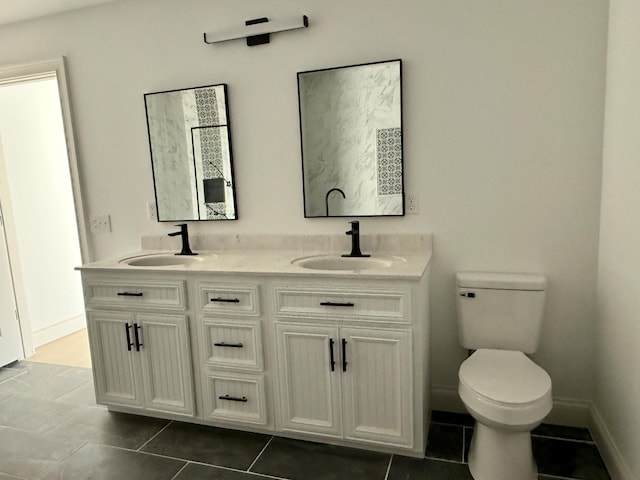 full bathroom featuring toilet, tile patterned flooring, double vanity, and a sink