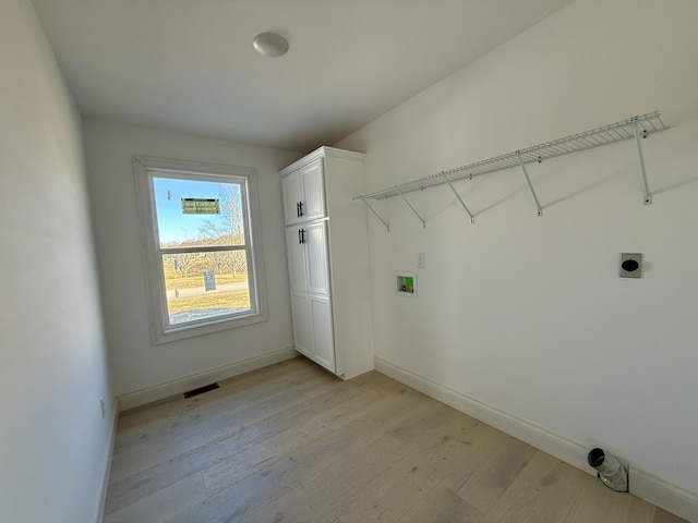 washroom featuring hookup for a washing machine, hookup for an electric dryer, light wood-style flooring, and baseboards