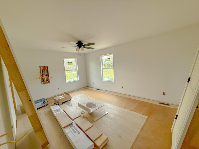 unfurnished room with light wood-style flooring, visible vents, and a ceiling fan