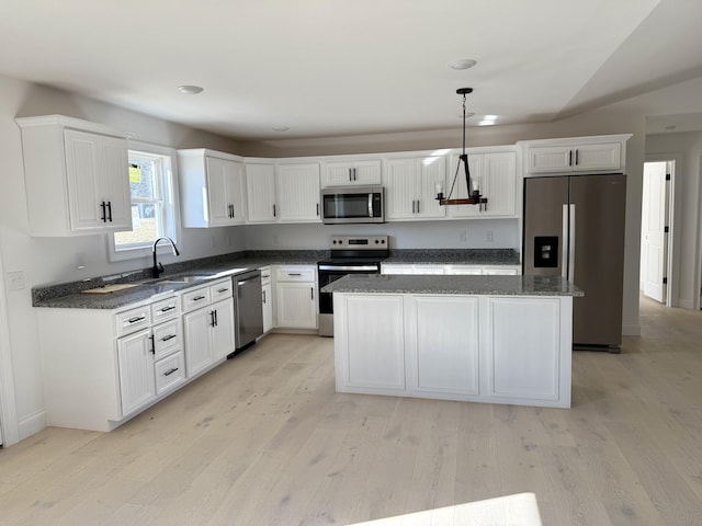 kitchen featuring appliances with stainless steel finishes, light wood-type flooring, a sink, and white cabinetry